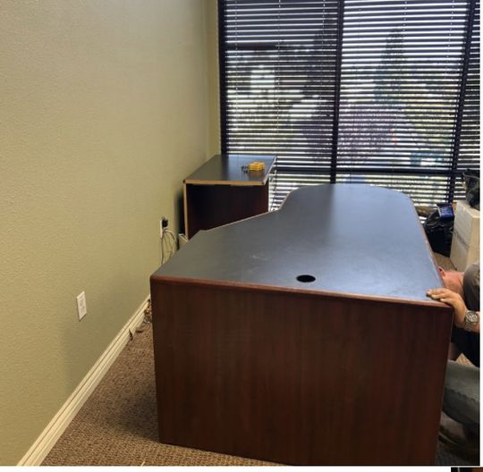 Gilroy office with a large desk and furniture before commercial cleanout