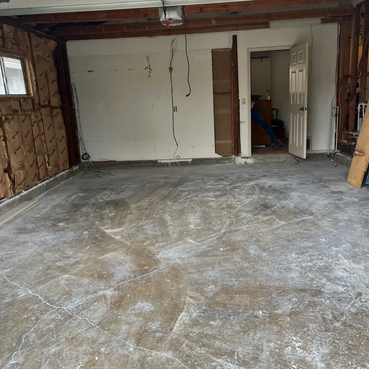 Same garage swept down to bare concrete after demo debris removal